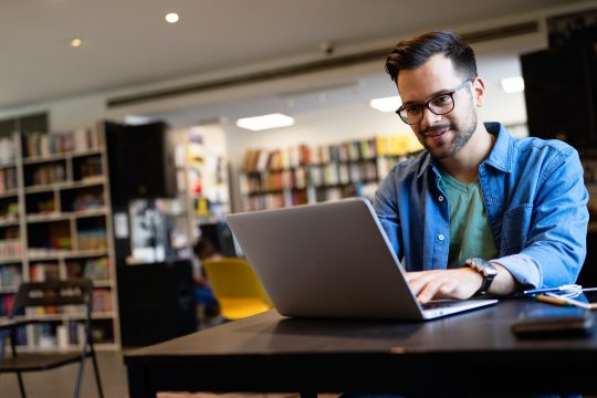 Student preparing exam and learning lessons in school library