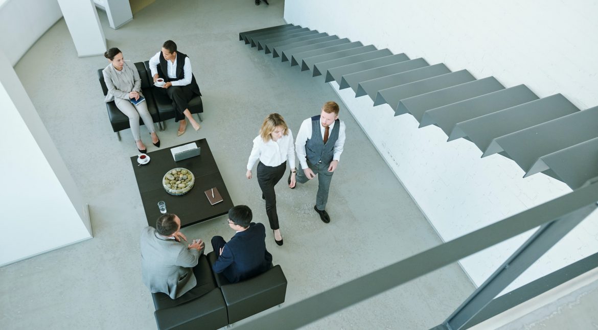 Three little groups of business people discussing working points at break