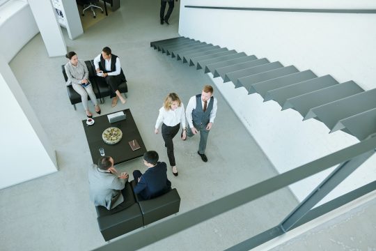 Three little groups of business people discussing working points at break